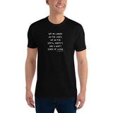 Black t-shirt worn by a gay man, emblazoned with the empowering mantra 'We No Longer Go For Looks' in bold white letters