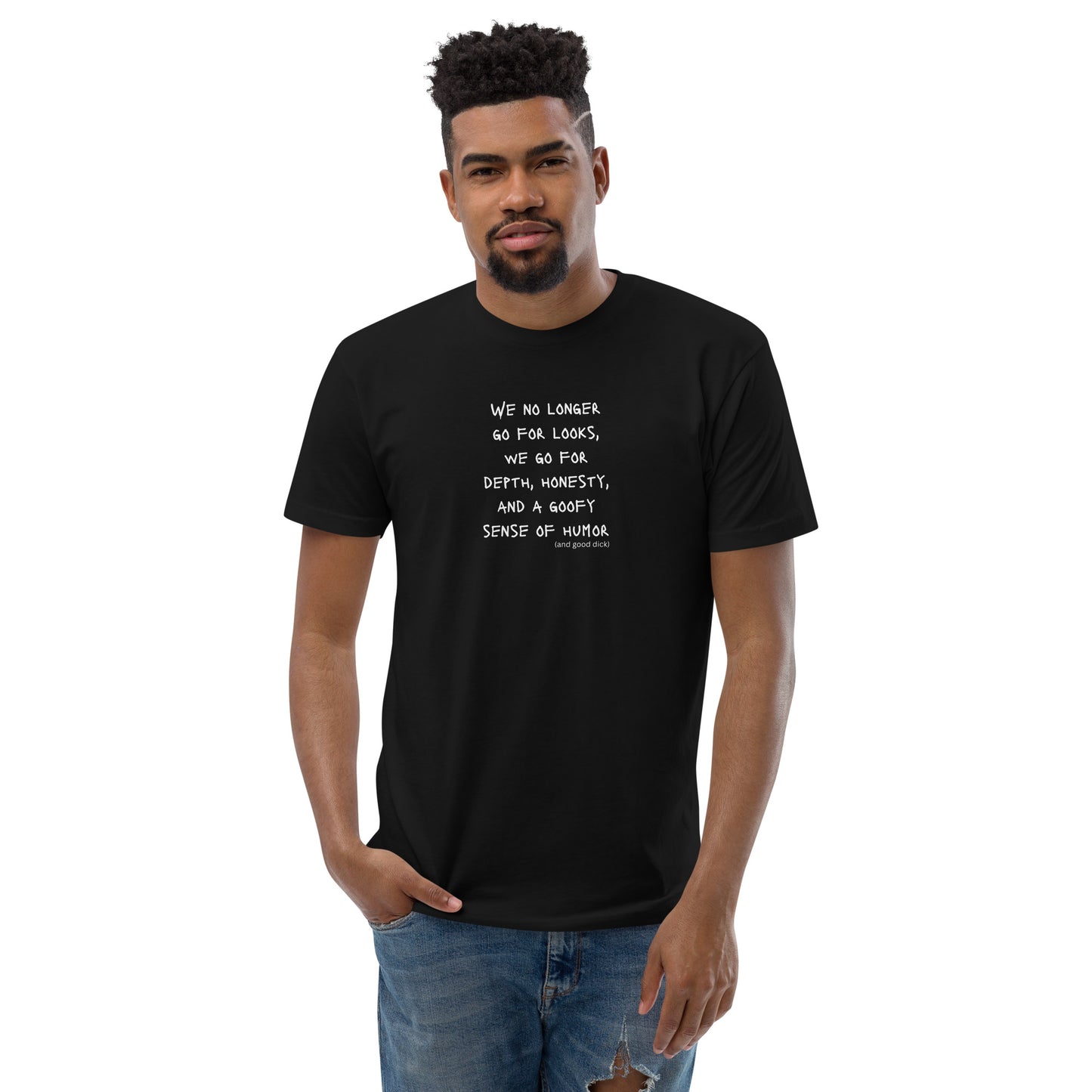 Black t-shirt worn by a gay man, emblazoned with the empowering mantra 'We No Longer Go For Looks' in bold white letters