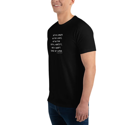 Black t-shirt worn by a gay man, emblazoned with the empowering mantra 'We No Longer Go For Looks' in bold white letters